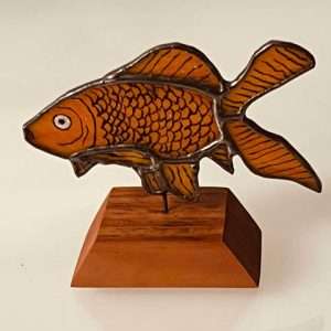 Orange stained glass goldfish on a wooden base